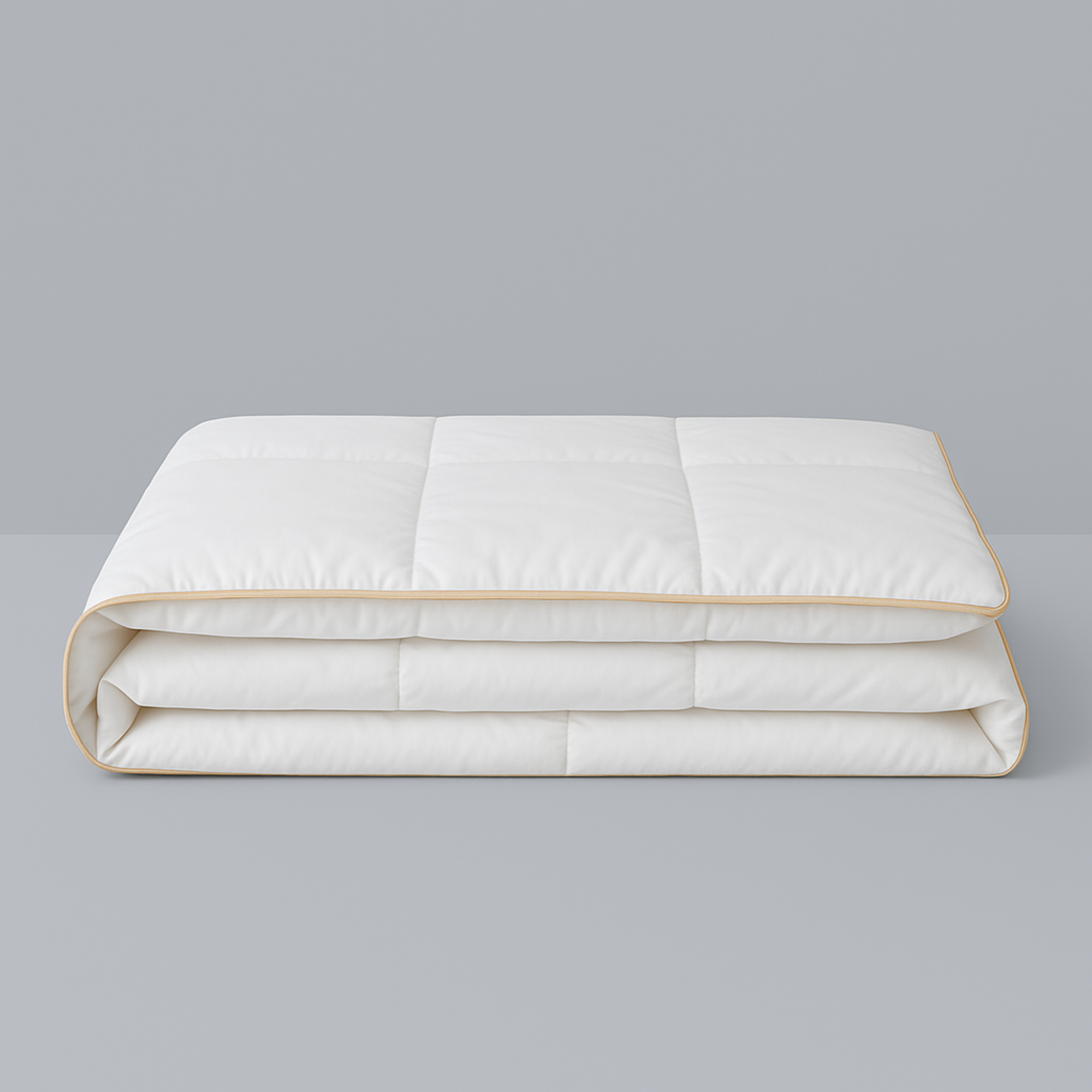 Royal Elite Silk Duvet Comforter folded on a grey background, showing box stitch panels and gold piped edging