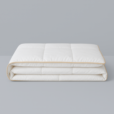 Royal Elite Silk Duvet Comforter folded on a grey background, showing box stitch panels and gold piped edging