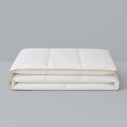 Royal Elite Silk Duvet Comforter folded on a grey background, showing box stitch panels and gold piped edging