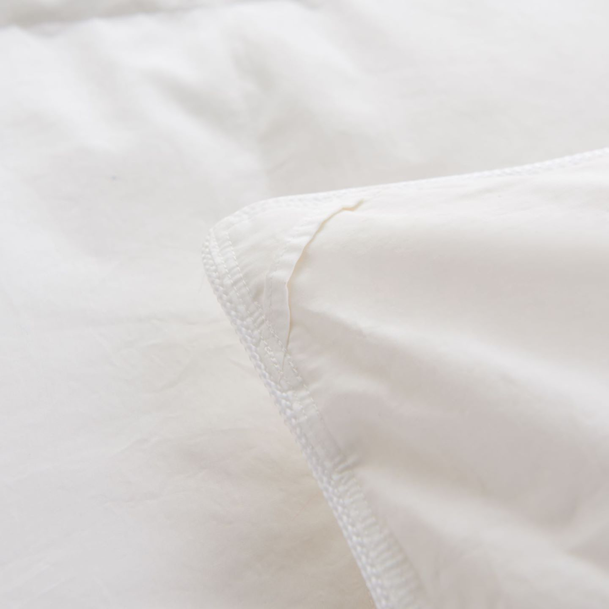 Close-up of Royal Elite Canadian Hutterite White Duck Down Duvet Insert Comforter with 800 fill power, featuring a 400 thread count cotton sateen down proof shell and finely finished edge. Corner loops.