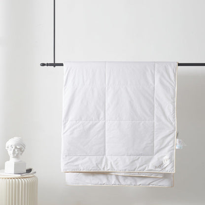 Royal Elite Silk Duvet hanging from a rail, showing box stitch panels, gold piped edge and embroidered logo.